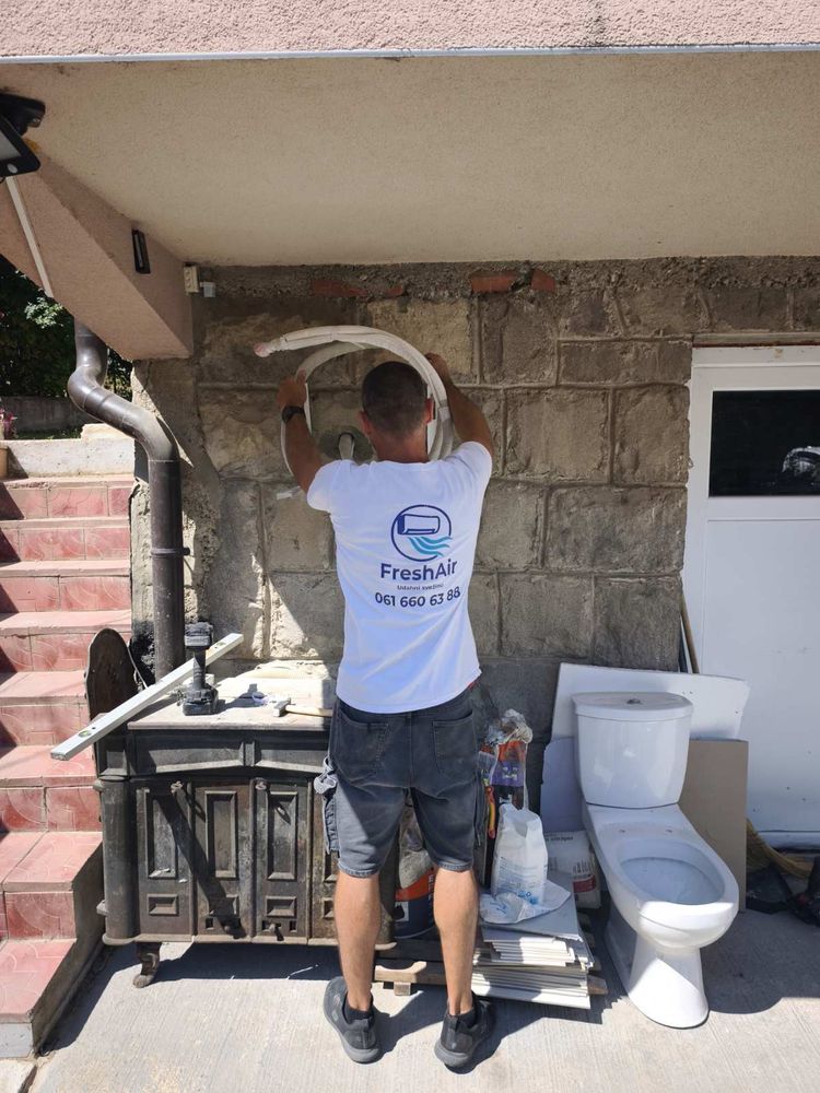 Majstor vodi bakarnu instalaciju klime po spoljnom zidu kuće